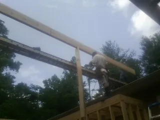 Carpenter setting a ridge beam over a new addition frame — Ice Dam Removal by Roofing Brothers in Jemez Pueblo