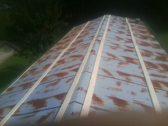 Rusted metal roof panels with new wood purlins before replacement — Storm Damage Roof Repair in Jemez Pueblo by Roofing Brothers