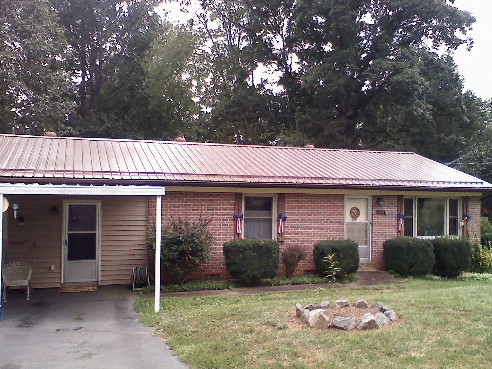 Bronze metal roof and carport on a brick ranch home — Roof Repair work by our crew in Jemez Pueblo