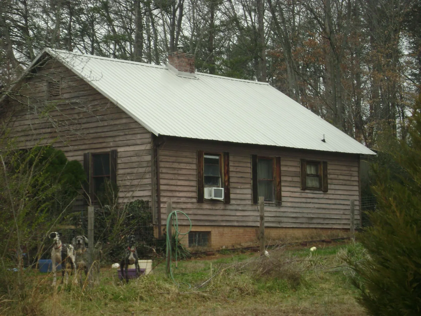White metal roof on an old wood sided farmhouse, from a Metal Roof Installation job in Jemez Pueblo